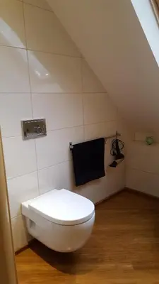 a bathroom with a white toilet and a black towel at Beskidzka Chata in Hucisko