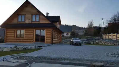 a car parked in front of a log house at Beskidzka Chata in Hucisko