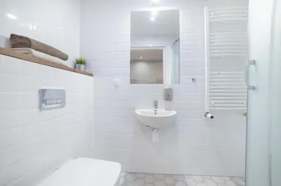 a white bathroom with a sink and a toilet at Dizzy Daisy Downtown Apartments in Kraków