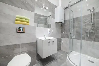a bathroom with a toilet and a shower and a sink at Dizzy Daisy Downtown Apartments in Kraków