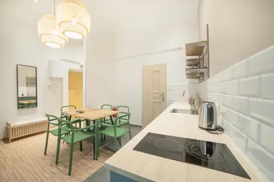 a kitchen with a table and chairs in a room at Dizzy Daisy Downtown Apartments in Kraków