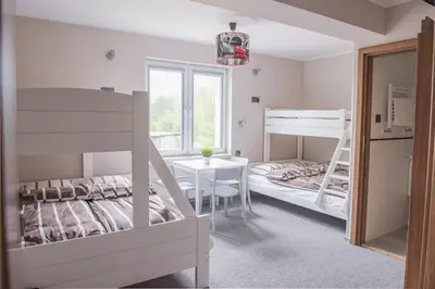 a bedroom with two bunk beds and a table at B&M Guesthouse in Oświęcim