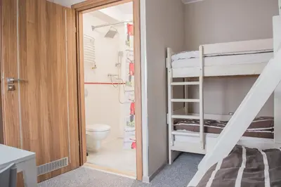 a small room with a bunk bed and a bathroom at B&M Guesthouse in Oświęcim