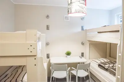 a room with two bunk beds and a table and chairs at B&M Guesthouse in Oświęcim