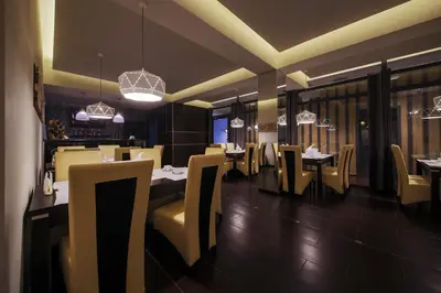 a dining room with tables and chairs and chandeliers at B&M Guesthouse in Oświęcim
