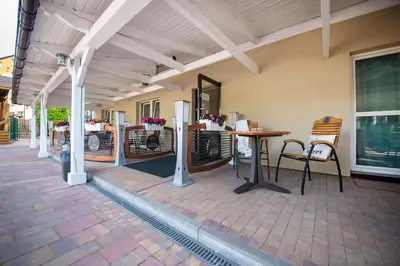 a patio with a table and chairs on a building at B&M Guesthouse in Oświęcim