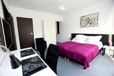 a bedroom with a bed with a purple blanket at Pure Apartments Kraków in Kraków