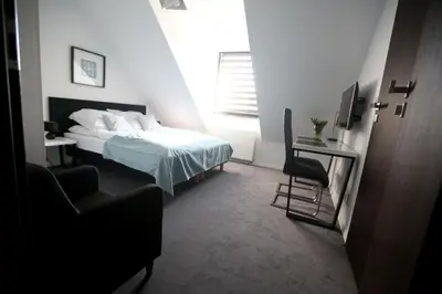 a bedroom with a bed and a desk and a television at Pure Apartments Kraków in Kraków