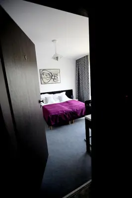 a bedroom with a bed with a purple blanket at Pure Apartments Kraków in Kraków