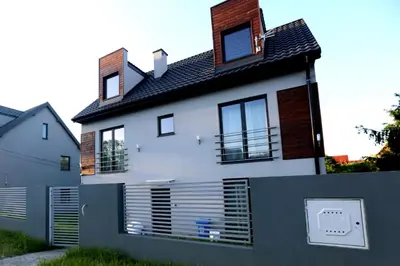 a white house with a fence in front of it at Pure Apartments Kraków in Kraków