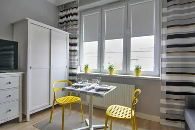 a dining room with a table and two yellow chairs at Apartment I GrayFor2 Old Town Kraków in Kraków