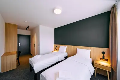 two beds in a room with white sheets at RABKA ZDRÓJ Cegielski - pokoje wyremontowane in Rabka