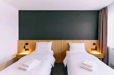 two beds in a room with a green wall at RABKA ZDRÓJ Cegielski - pokoje wyremontowane in Rabka