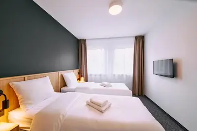 a hotel room with two beds and a tv at RABKA ZDRÓJ Cegielski - pokoje wyremontowane in Rabka