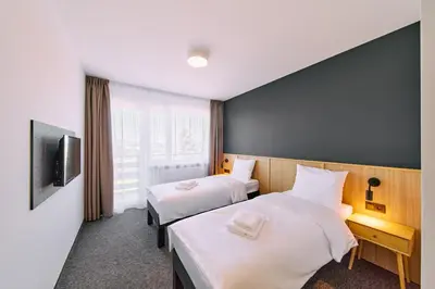 a hotel room with two beds and a tv at RABKA ZDRÓJ Cegielski - pokoje wyremontowane in Rabka