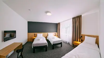 a hotel room with two beds and a tv at RABKA ZDRÓJ Cegielski - pokoje wyremontowane in Rabka
