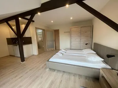 a large white bed in a room with wooden floors at Apartamenty w Rynku in Rabka