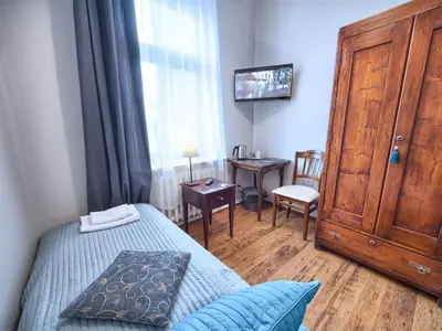 a bedroom with a bed with a wooden cabinet and a window at Pokoje gościnne 