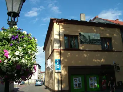 a building on the side of a street next to a tree at Pokoje gościnne 