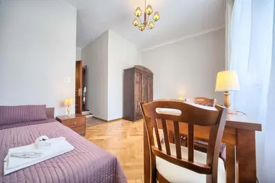 a bedroom with a bed and a table and a chair at Pokoje gościnne 