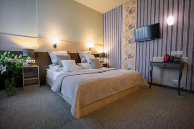 a hotel room with a large bed and a flat screen tv at Hotel Kazimierz III in Kraków