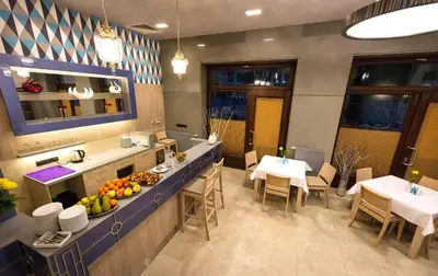 a restaurant with two tables and a counter with fruit on it at Hotel Kazimierz III in Kraków