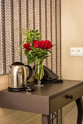a vase of red roses sitting on a table at Hotel Kazimierz III in Kraków