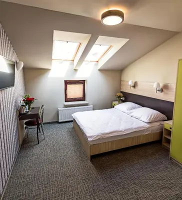 a bedroom with a large bed and skylights at Hotel Kazimierz III in Kraków