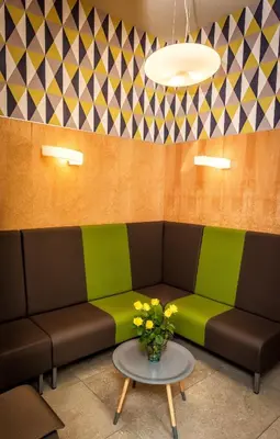 a room with a couch and a table with flowers at Hotel Kazimierz III in Kraków