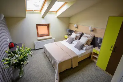 a bedroom with a bed in a room with windows at Hotel Kazimierz III in Kraków