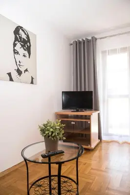 a living room with a table and a tv at Villa Verona in Kraków