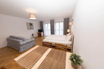 a living room with a bed and a chair at Villa Verona in Kraków