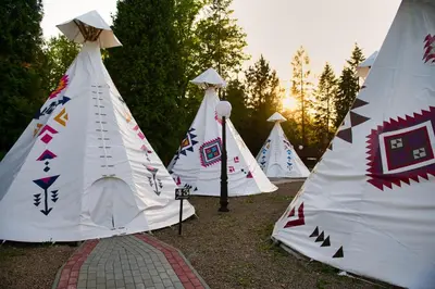 a row of teepee tents in a field at Wioska Indiańska River Park Zator SPA RESORT in Zator