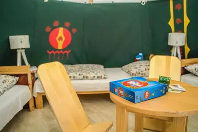 a room with a bed and a table with a box on it at Wioska Indiańska River Park Zator SPA RESORT in Zator