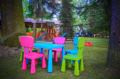 a table and chairs in front of a playground at Wioska Indiańska River Park Zator SPA RESORT in Zator