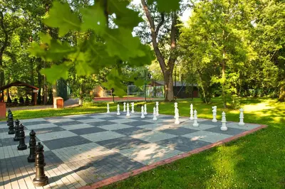 a chess board on a sidewalk in a park at Wioska Indiańska River Park Zator SPA RESORT in Zator