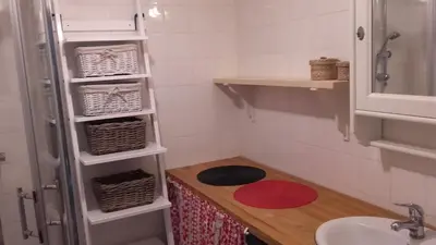 a small bathroom with a sink and a refrigerator at Dom w górach in Zawoja