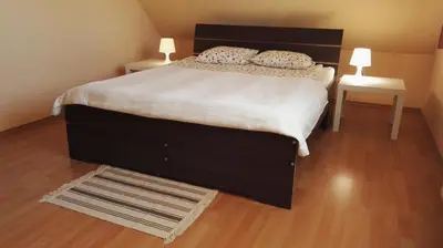 a bedroom with a large bed with white sheets and two lamps at Willa Elżbieta in Kraków