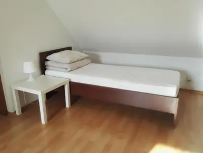 a bed in a room with a side table at Willa Elżbieta in Kraków