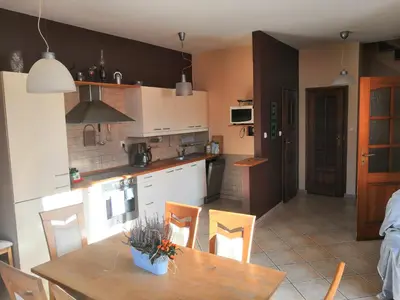 a kitchen and dining room with a table and chairs at Willa Elżbieta in Kraków
