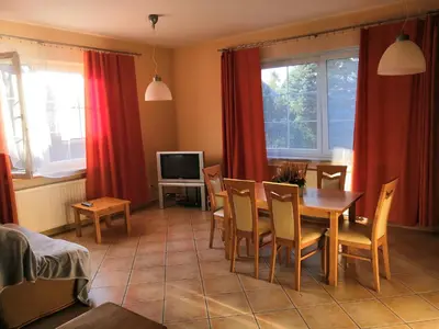 a living room with a table and chairs and a television at Willa Elżbieta in Kraków