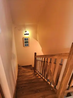 a wooden staircase with a light on the wall at Willa Elżbieta in Kraków