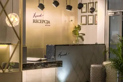 a lobby with a desk and plants on the wall at Hotel Kossak in Kraków
