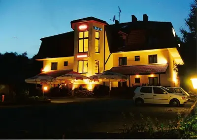 a building with a car parked in front of it at Hotel Twardowski in Głogoczów