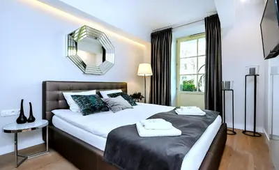 a bedroom with two beds and a mirror on the wall at Premium Apartments by Wawel Castle in Kraków
