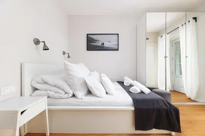 a white bedroom with white pillows on a bed at Premium Apartments by Wawel Castle in Kraków