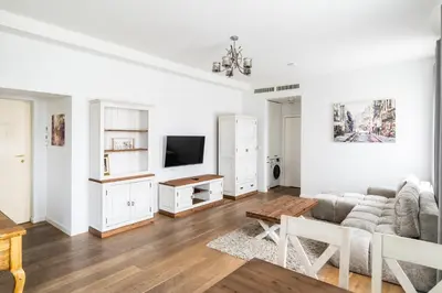 a white living room with a couch and a tv at Premium Apartments by Wawel Castle in Kraków