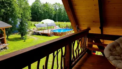 a balcony with a view of a backyard with a pool at Chata w Rabce - Bajkowa Osada in Rabka