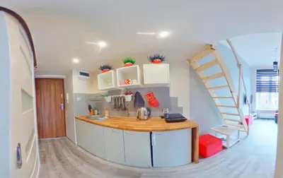 a kitchen with a sink and a staircase in a room at Apartamenty Marco - Stare Miasto - Super Wi Fi in Kraków