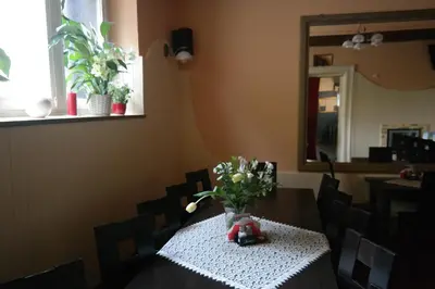 a dining room with a table with a vase of flowers at Apartamenty Marco - Stare Miasto - Super Wi Fi in Kraków